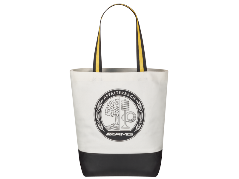 AMG shopping bag. Off-white/black. 100% cotton. Carrying strap with yellow contrasting stripe. Zipped pocket inside. Rubberized black printed on the bottom. Black printed Affalterbach coat of arms at the front, silver gray embroidered AMG Classic logo at the rear. Dimensions approx. 28.5 x 13.5 x 39.5 cm.